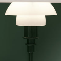 Sleek black lamp base with two white conical shades against a dark green background. Elegant, modern design.