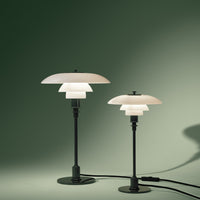 Set of two modern lamps featuring white shades and black bases against a muted green background.