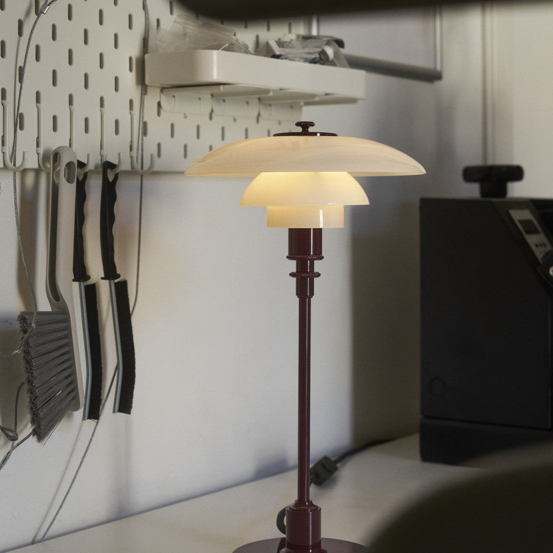 Modern lamp featuring a white glass shade and a deep burgundy base, with clean lines and minimalistic design.