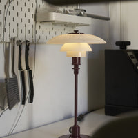 Modern lamp featuring a white glass shade and a deep burgundy base, with clean lines and minimalistic design.