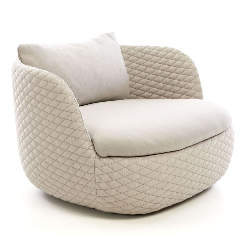 Cream quilted armchair with a smooth rounded shape and plush cushion. Elegant, modern design for stylish interiors.
