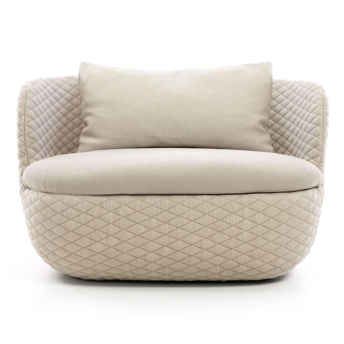 Beige upholstered sofa with diamond-patterned fabric and soft cushion pillows, exuding modern elegance.