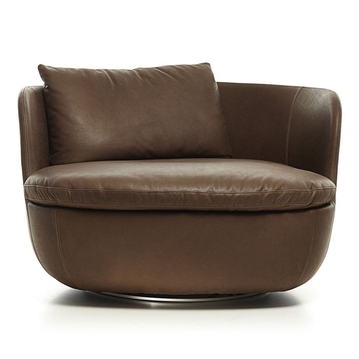 Round brown leather lounge chair with a smooth finish and plush accent pillow, featuring a sleek chrome base.