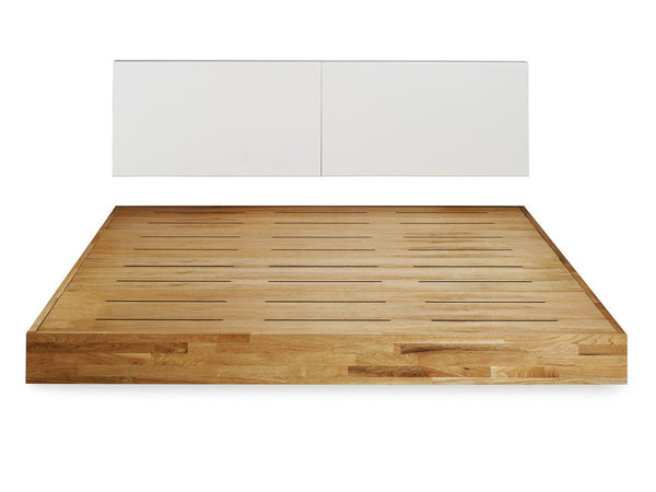 Natural wood grain bed frame with slatted design and smooth white headboard for a modern, minimalist look.