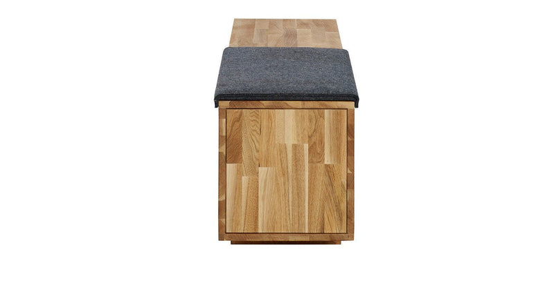 Wooden bench with a natural finish and a dark gray cushion on top. Simple, modern design with a sleek pattern.