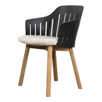 Black slatted chair with a cream cushion and natural wood legs perfect for modern decor.