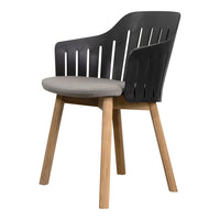 Black slatted back chair with gray cushion and natural wood legs. Modern design for stylish interiors.