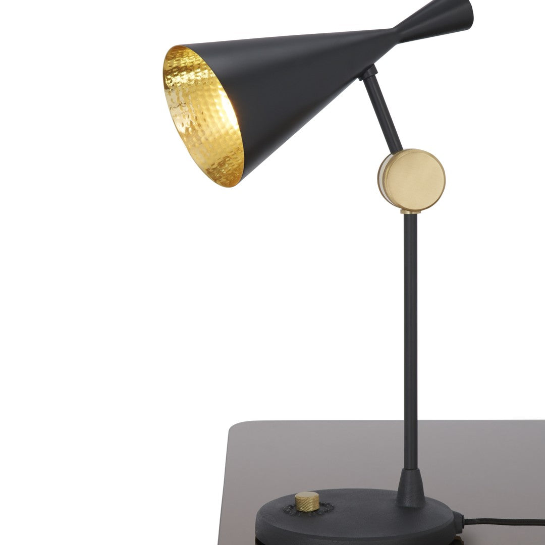 Black and gold desk lamp with a conical shade and textured interior, featuring a sleek modern design.