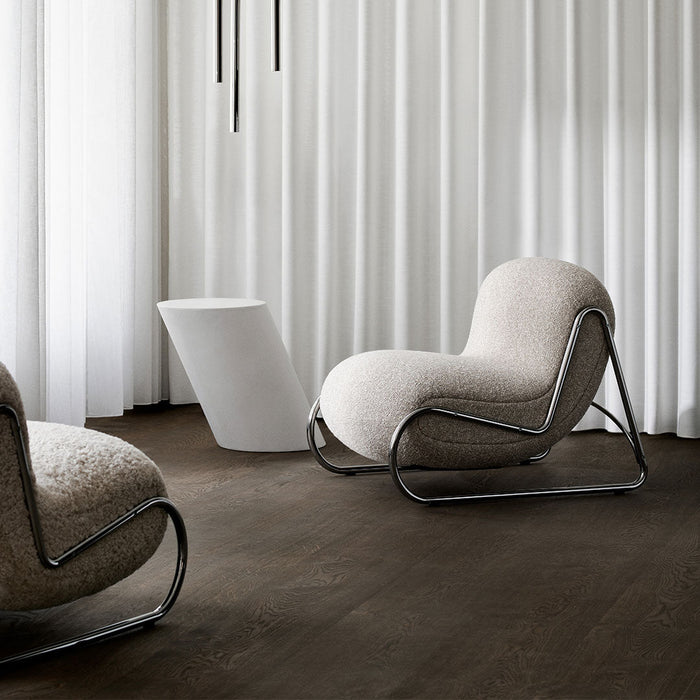Soft beige boucle upholstery with sleek black metal accents on modern rocking chairs against a minimalist gray backdrop.