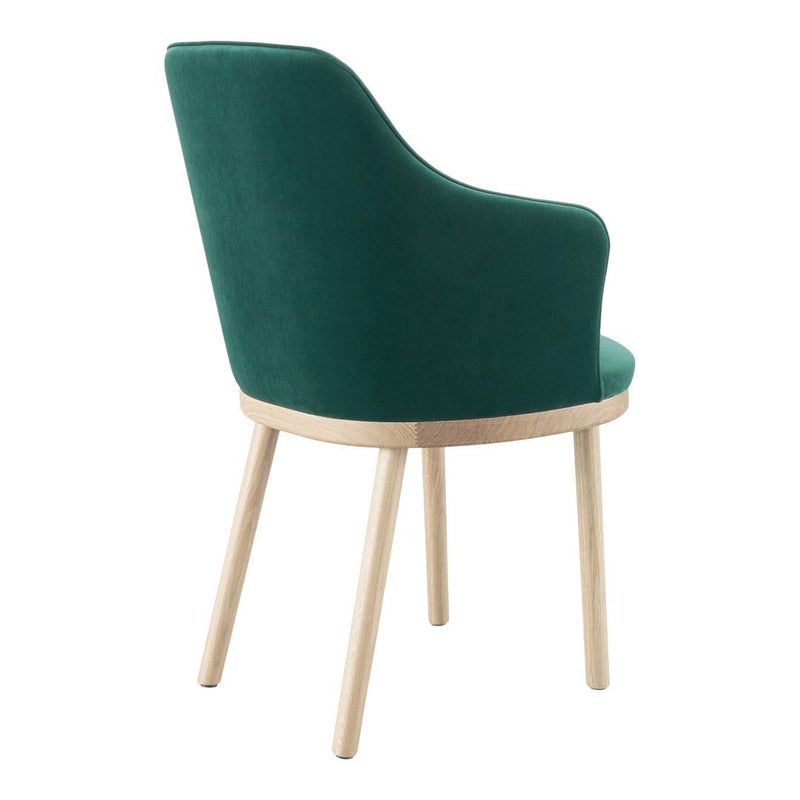 Green velvet chair with a curved back and light wooden legs, featuring a soft, solid color and sleek design.