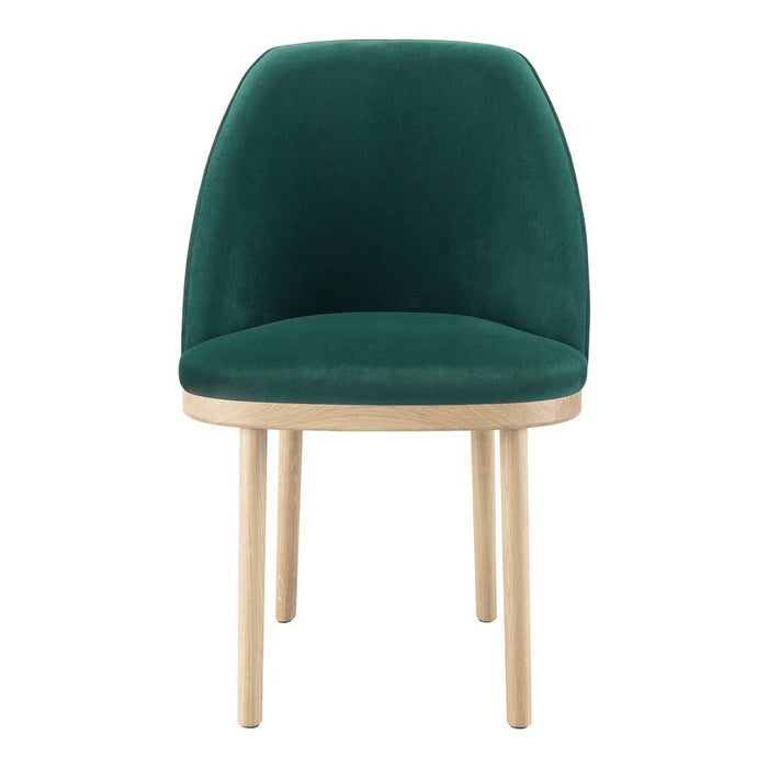 Green velvet chair with a smooth finish and natural wood legs, featuring a minimalist design.