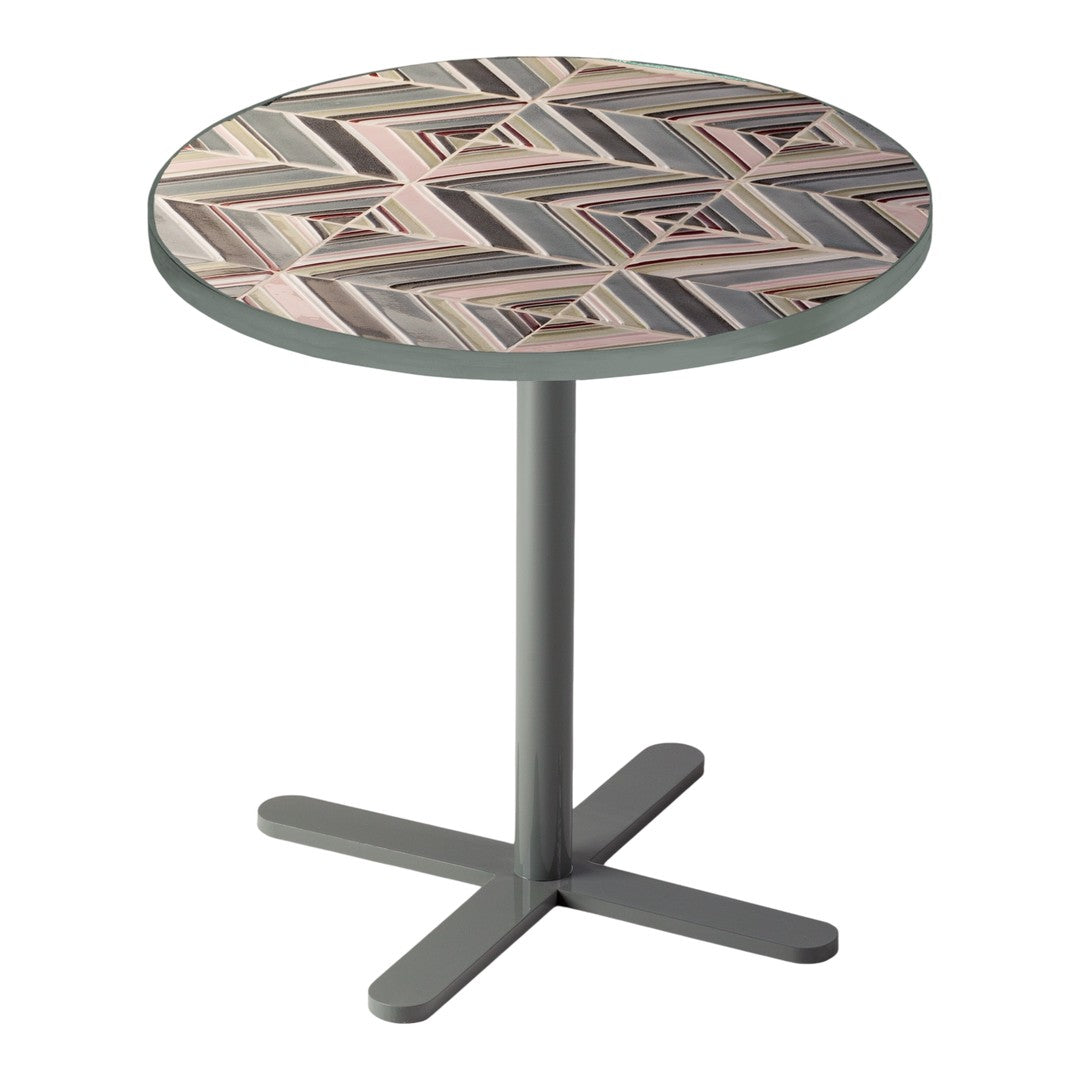 Round table featuring a geometric chevron pattern in soft pinks, grays, and cream on a sleek gray base.
