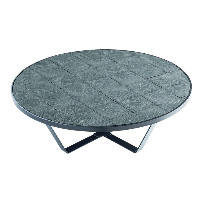 Round coffee table with a textured gray surface and geometric patterns, set on sleek black metal legs.