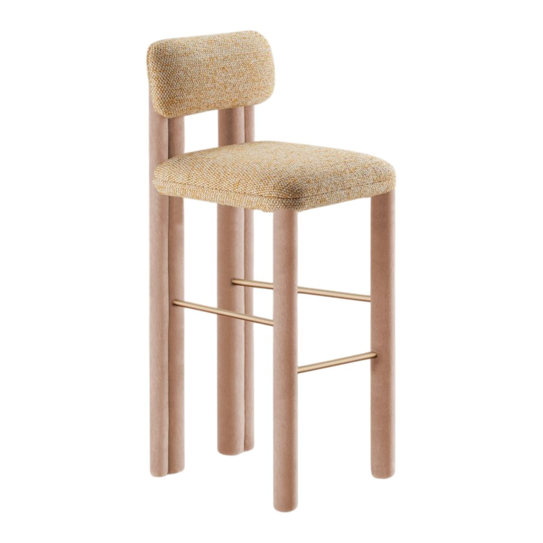 Beige textured upholstery on a modern bar stool with light pink wooden legs and a gold footrest.