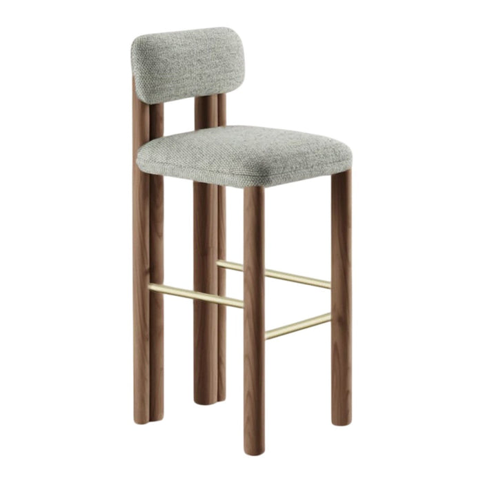 Gray upholstered barstool with smooth wood legs and a subtle brass footrest. Modern design for stylish decor.