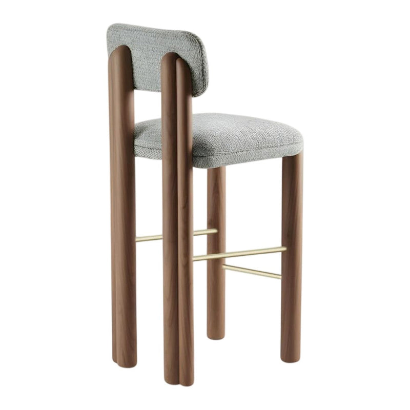 Gray upholstered bar stool with brown wooden legs and a gold metal footrest, featuring a sleek, modern design.