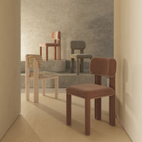 Colorful chairs in earthy tones of brown, gray, and beige with textured fabrics and smooth finishes, arranged artistically.