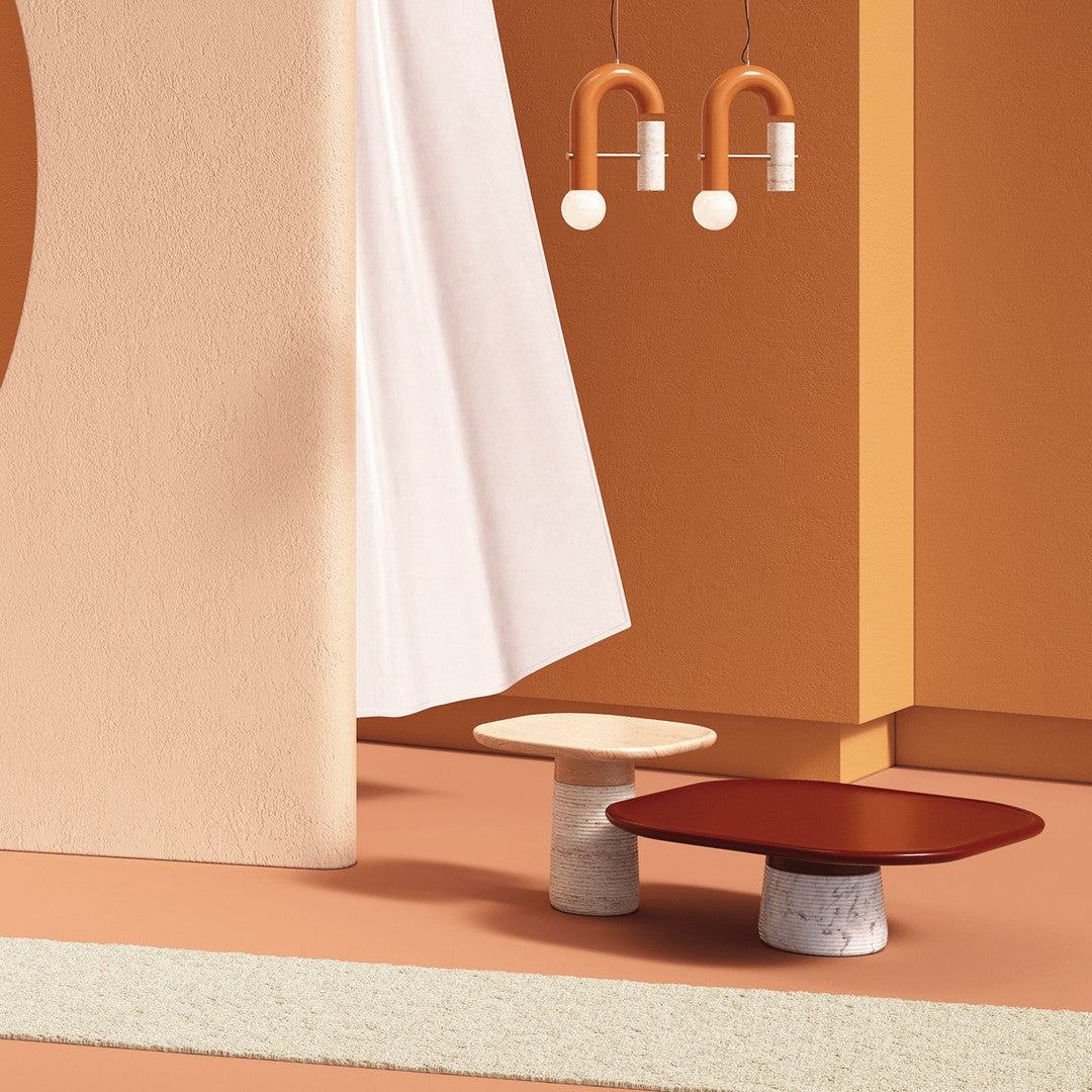 Two modern side tables in earthy tones of beige and rust, set against a backdrop of soft peach and cream textures.