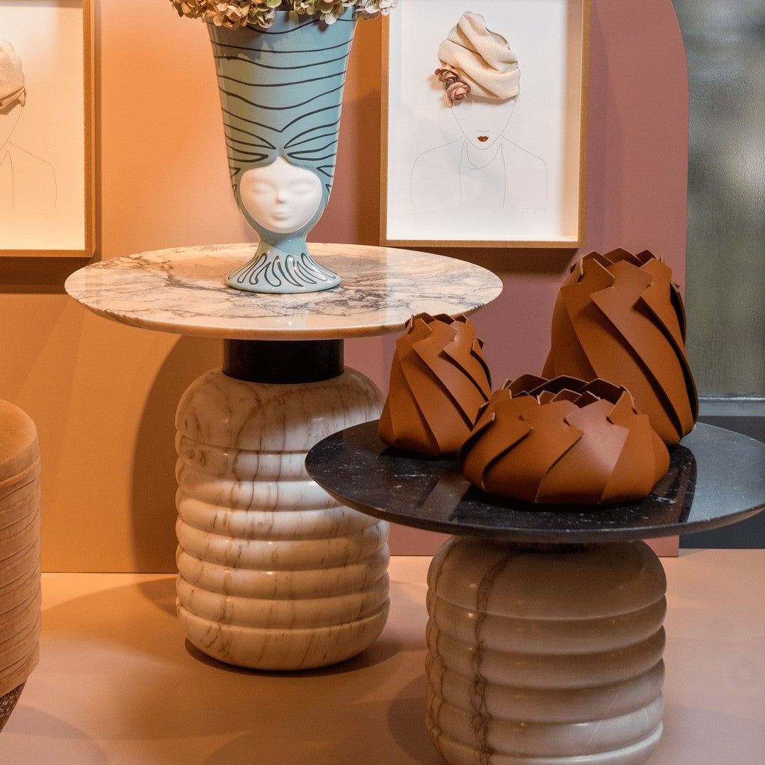 Elegant marble tables with earthy tones, featuring bold striped and sculptural patterns for a modern aesthetic.
