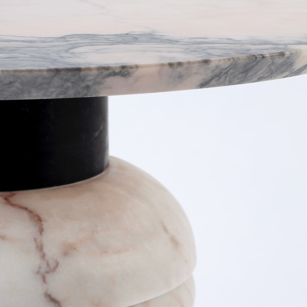 Marble tabletop with gray and white veining, paired with a smooth beige base and a black accent.