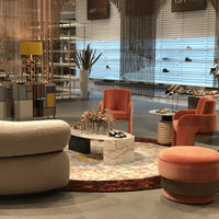 Stylish interior with soft pink chairs, geometric patterns, warm earthy tones, and unique decor elements.