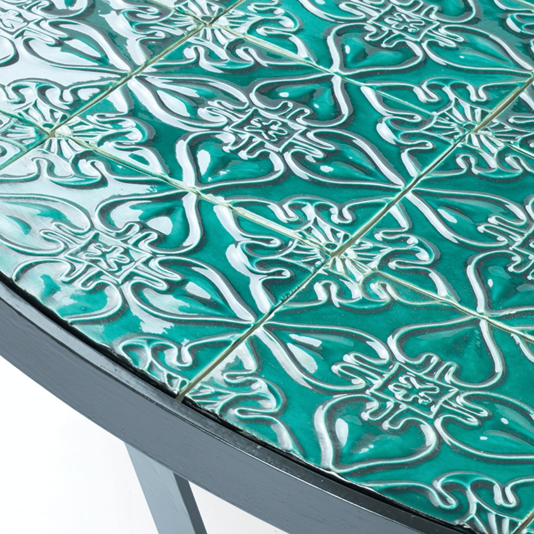 Teal patterned ceramic tile surface with intricate designs and glossy finish. Perfect for stylish home decor.