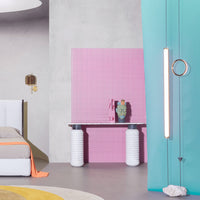 "Vibrant pink wall with geometric patterns, teal curtains, and a soft gray background, showcasing contemporary design."