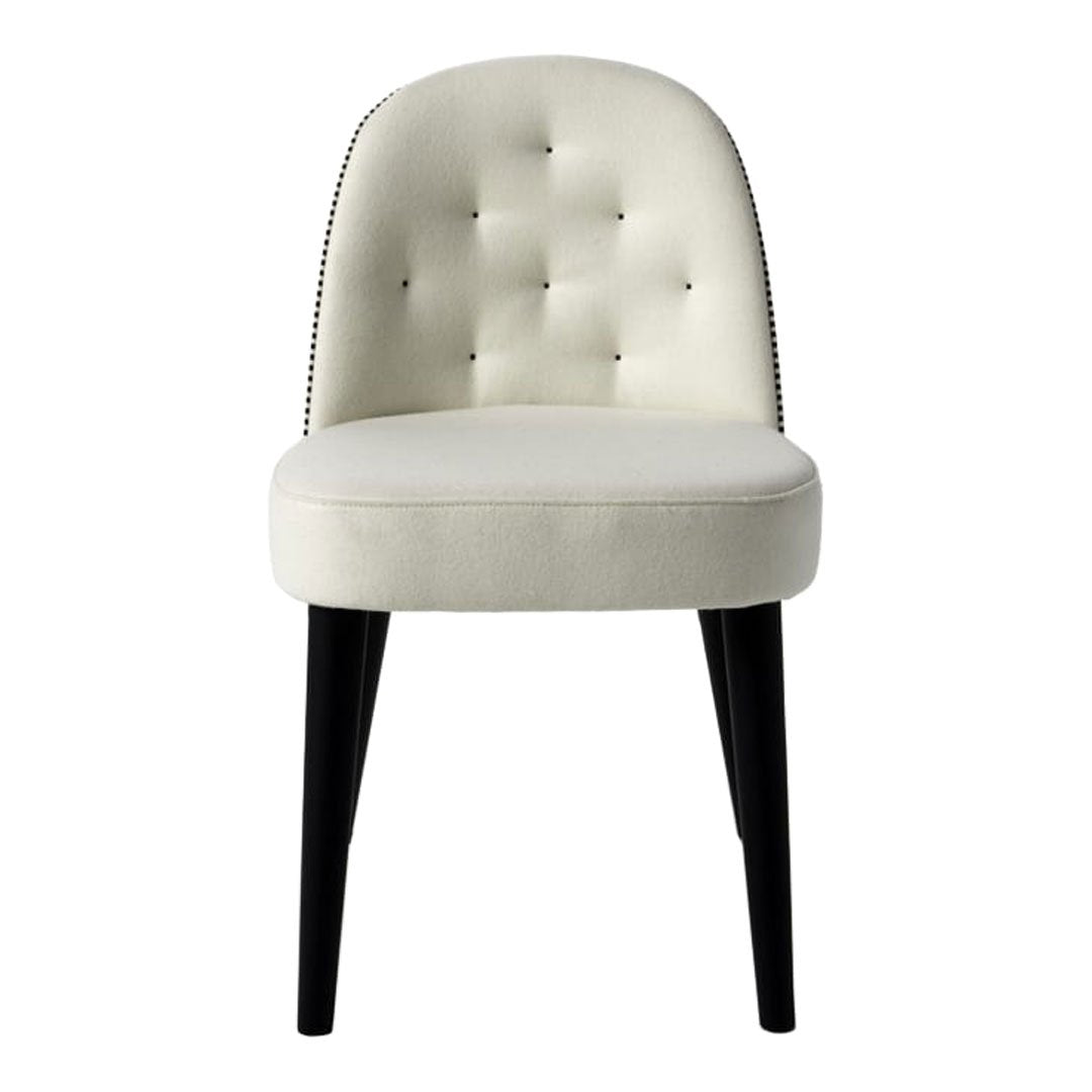 Cream tufted chair with black wooden legs and silver nailhead trim, featuring a smooth, contemporary design.