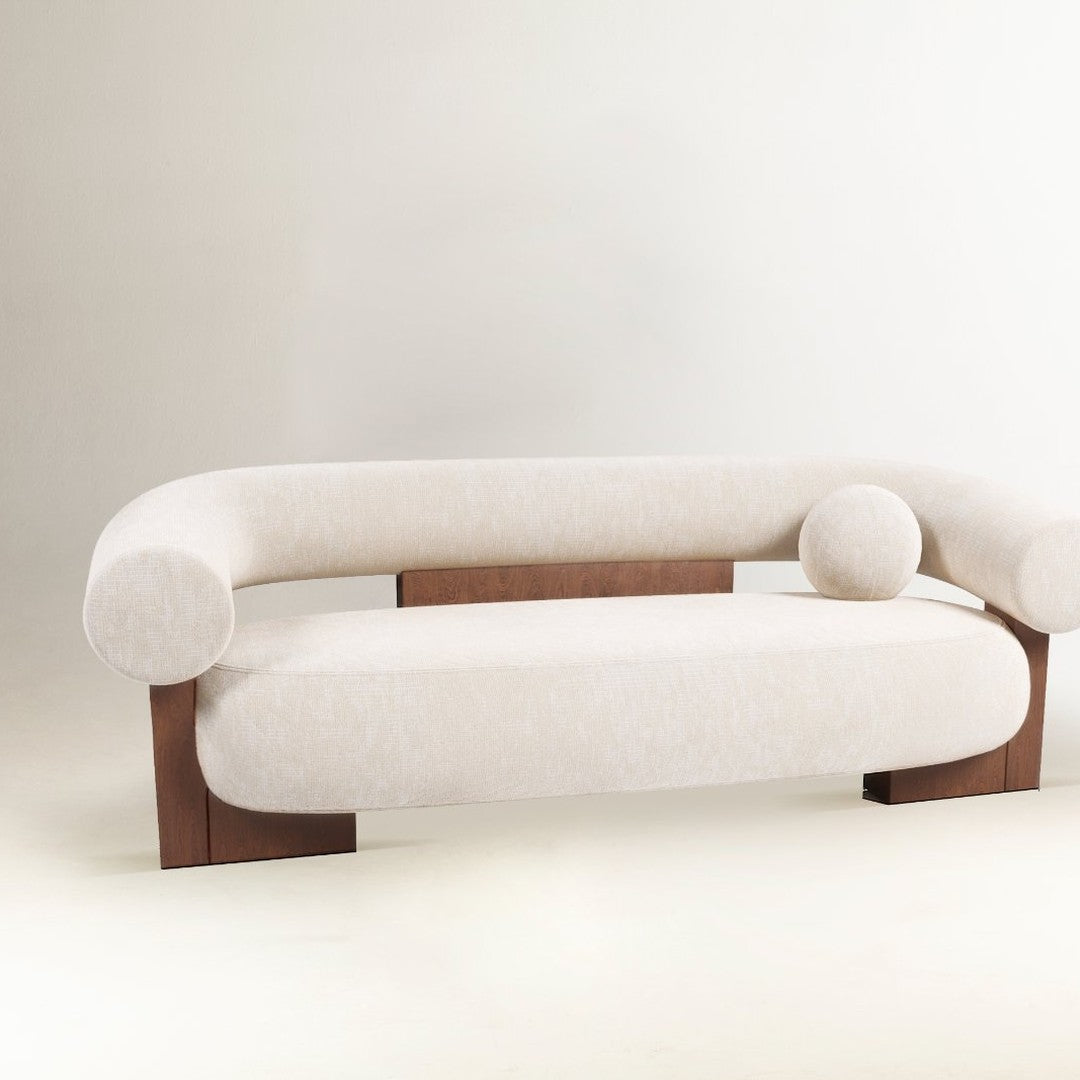Light beige curved sofa with wooden accents and smooth texture, featuring round cushions for added comfort.