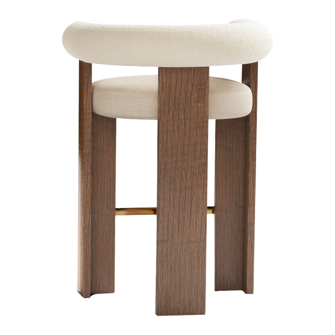 Beige upholstered stool with a stylish wooden base and gold accent, featuring a smooth, minimalist design.