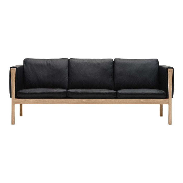 Black leather sofa with a minimalist design and natural wood armrests, showcasing a sleek and modern aesthetic.