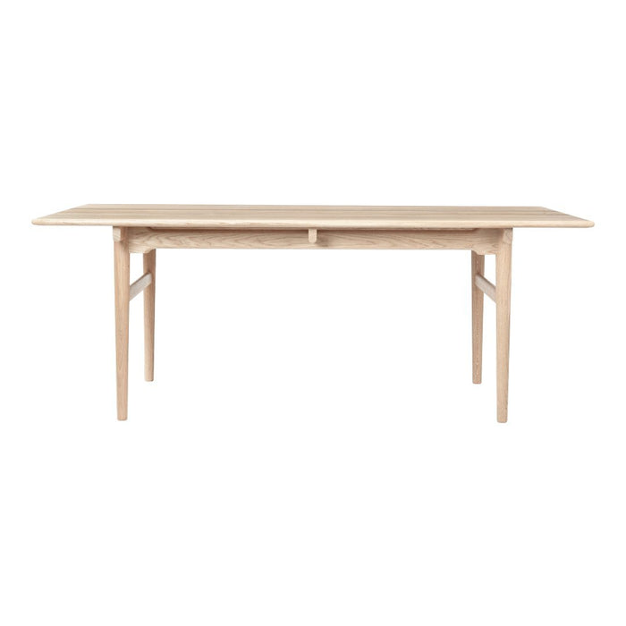 Light natural wood dining table with a smooth, minimalist design and tapered legs. Ideal for modern interiors.