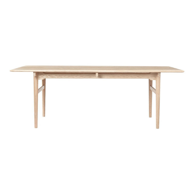 Light oak dining table with a smooth, natural finish and minimalist design for a modern aesthetic.