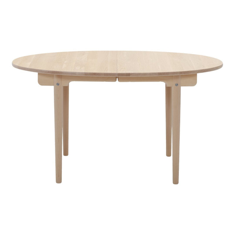 Natural wood round dining table with a smooth finish and minimalist design. Light beige color enhances any decor.