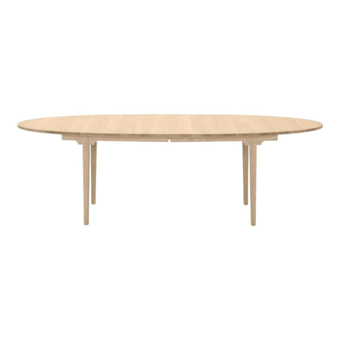 Light oak oval dining table with a smooth finish and elegant wood grain pattern. Perfect for modern interiors.