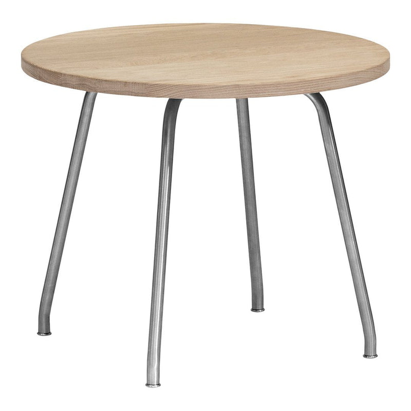 Round wooden table with a light oak surface and sleek silver legs, featuring a minimalist design.