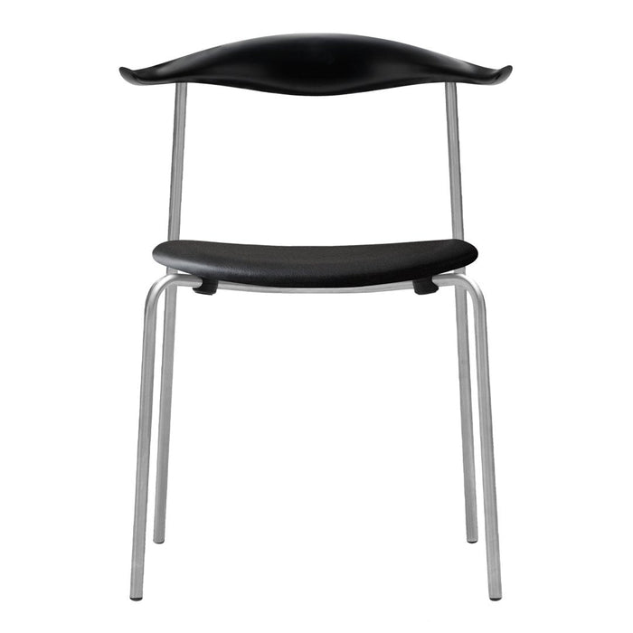 "Black minimalist chair with sleek silver legs and smooth, curved seat design."