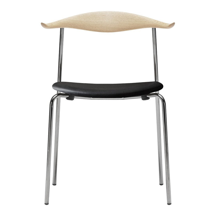 Stylish chair with a light wood backrest, black seat, and sleek chrome legs. Modern and minimalist design.
