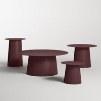 Set of four modern tables in rich burgundy with minimalist, smooth surfaces and varied cylindrical shapes.