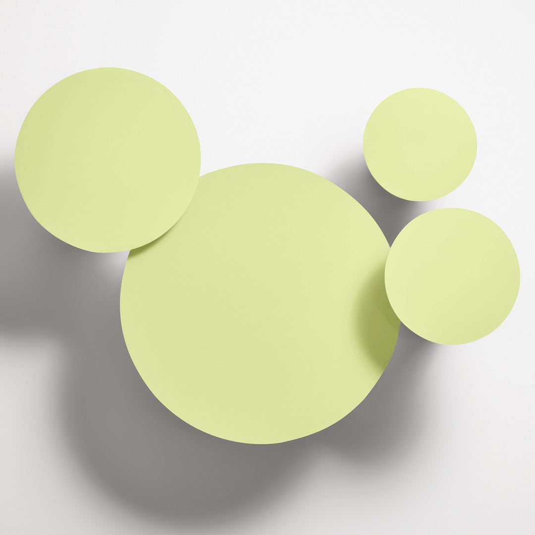 Light green circular wall decor featuring varying sizes for a playful, modern aesthetic. Ideal for brightening spaces.