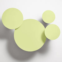 Light green circular wall decor featuring varying sizes for a playful, modern aesthetic. Ideal for brightening spaces.