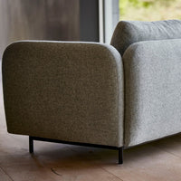 Gray upholstered sofa with rounded edges and minimalistic design, featuring a textured fabric and sleek black legs.