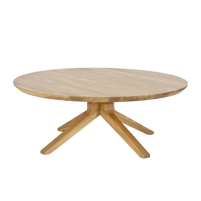 Round wooden coffee table in light oak finish with a smooth, natural grain pattern and four tapered legs.