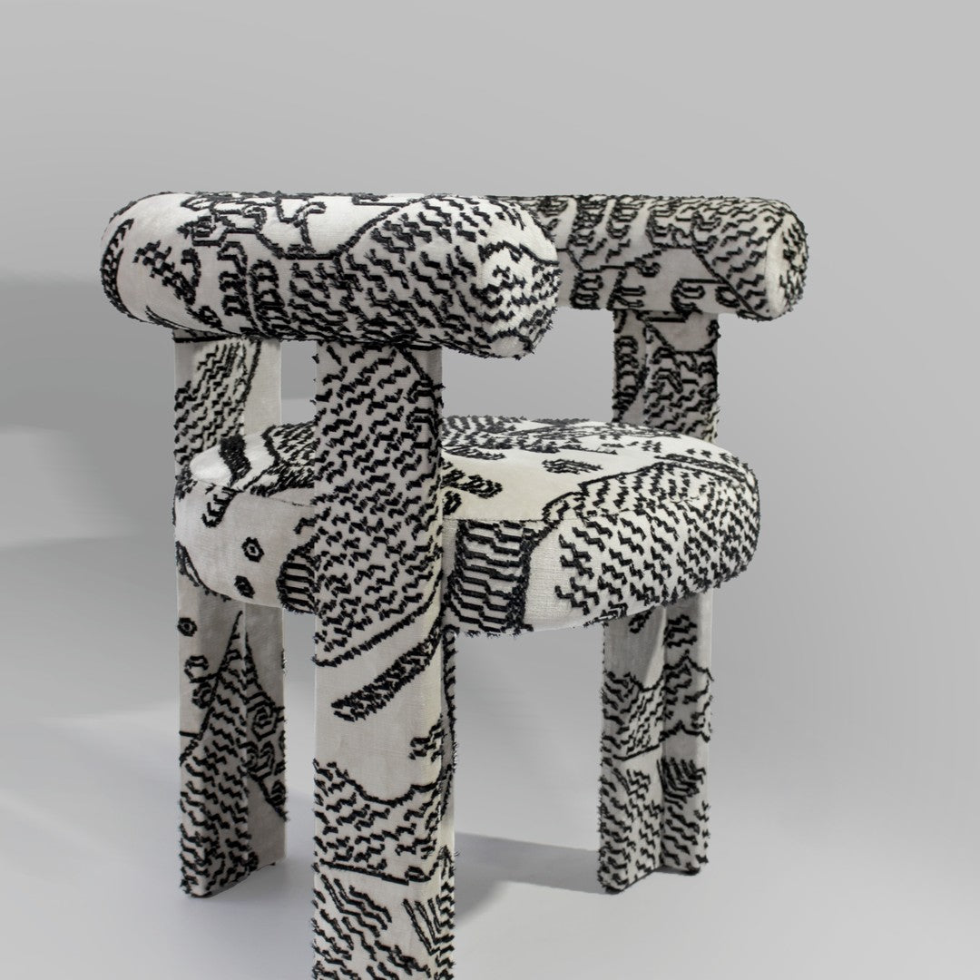 Black and white patterned chair with abstract designs and rounded edges, adding a modern touch to any space.