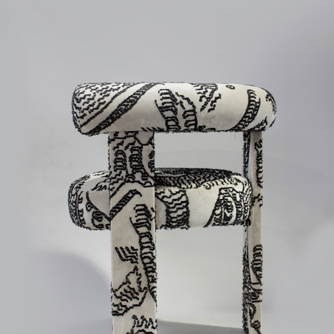 Black and white patterned chair featuring abstract lines and curves on a soft upholstery.