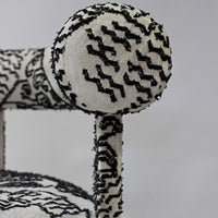 Black and white patterned upholstery featuring zigzag and geometric designs on plush furniture. 