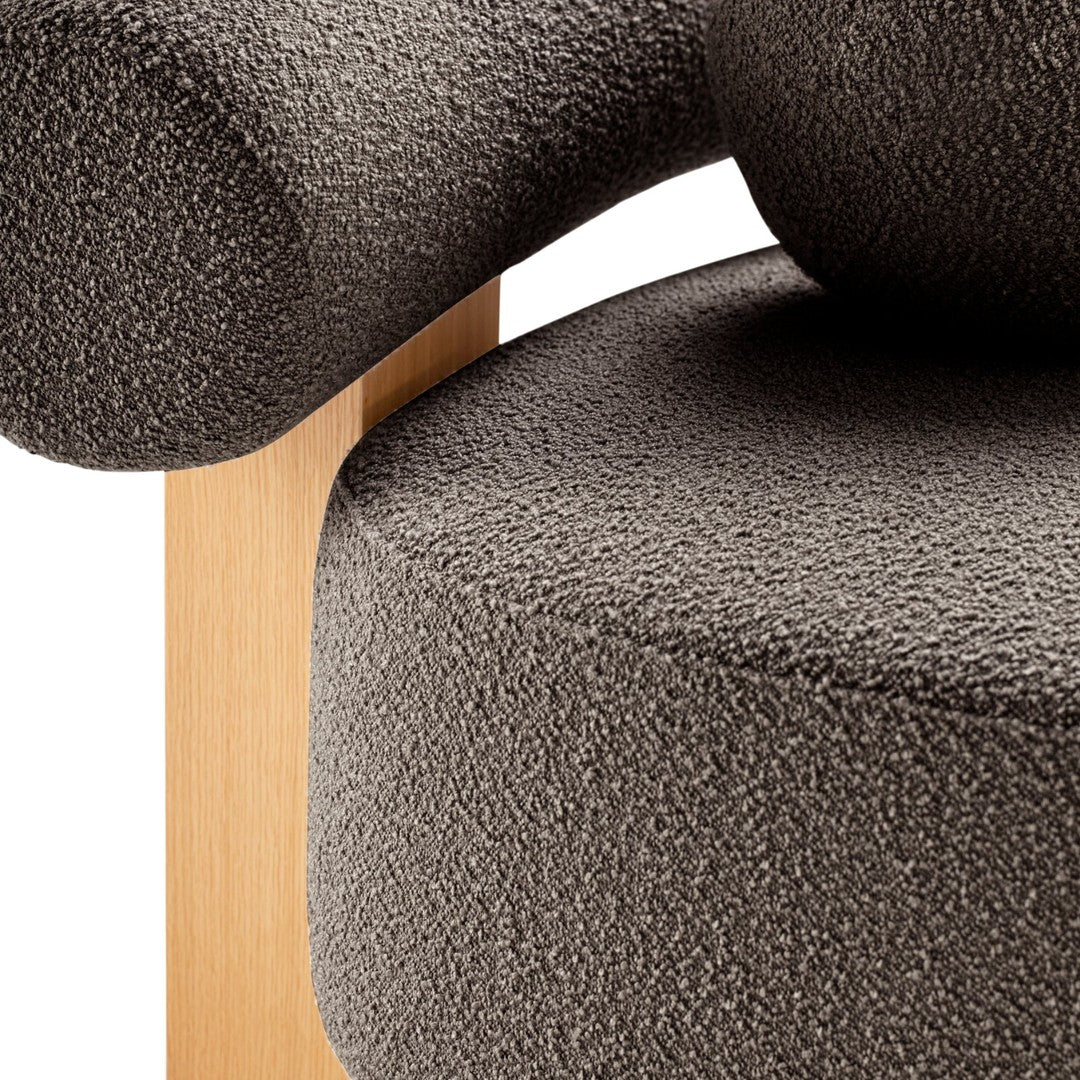 Textured dark gray upholstery on a minimalist chair with a natural wood frame. Soft, modern design elements.
