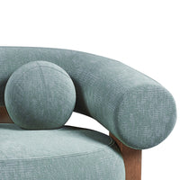 Soft green upholstery with textured patterns on a rounded chair arm and cushion, featuring a matching spherical accent.