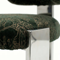 Green and gold patterned upholstery on a chair with a sleek chrome leg design.