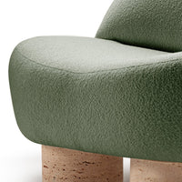 Soft green textured upholstery with smooth, rounded lines and natural cork legs, perfect for modern decor.